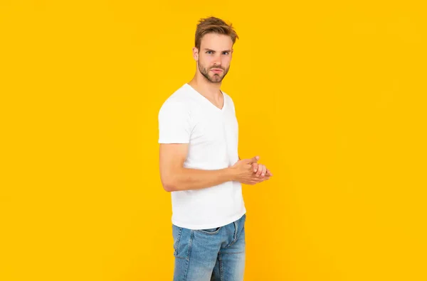 Unshaven young man in white shirt on yellow background, casual — Stock fotografie