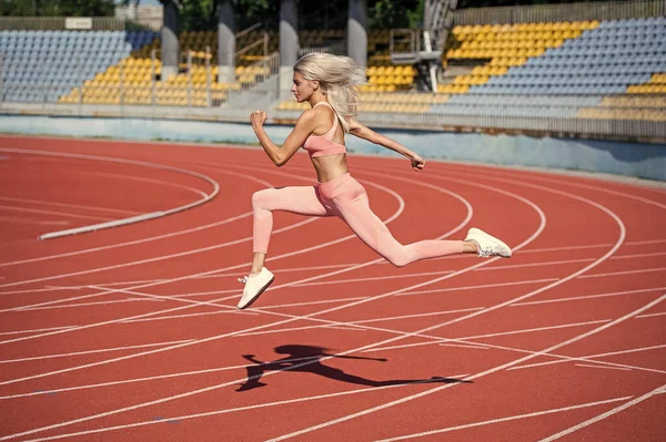 Spor salonundaki atletik kadın stadyumda koşuyor. — Stok fotoğraf