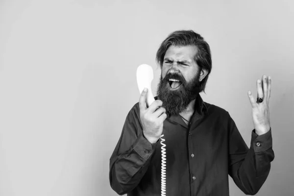 Cosa? L'uomo barbuto risponde alla chiamata. Un bell'uomo ha una conversazione. hipster maturo con barba con telefono retrò. brutale ragazzo caucasico parlare al telefono. concetto di comunicazione. copia spazio — Foto Stock