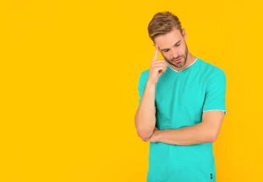 Kırmızı gömlekli, sarı arkaplanlı, fotokopi alanı olan sıradan bir adam.