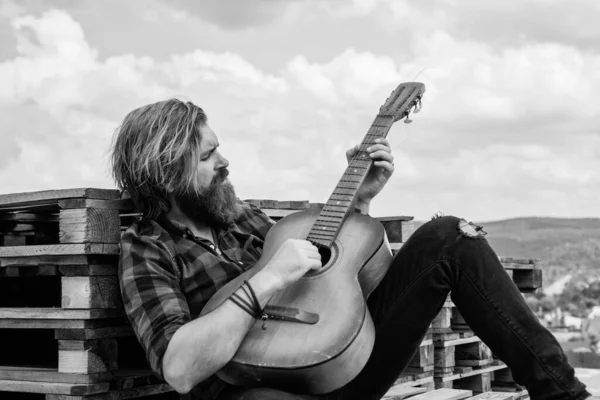 Tişörtlü, beyaz, vahşi hippi akustik gitar ve müzik çalıyor.