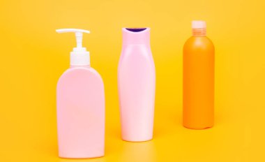 Güzellik paketi. Kozmetik şişeleri sarı arka plan. Tuvalet şişeleri sıraya dizildi.