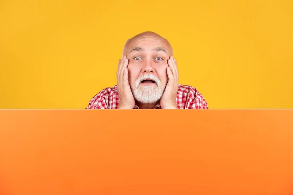 Shocked senior man with copy space on blank banner. advertisement — Foto Stock