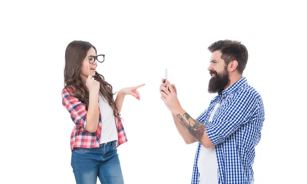 Menina filha criança com óculos de adereço posando para homem barbudo pai tirar foto com telefone, família — Fotografia de Stock