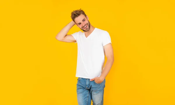 Smiling unshaven young man in white shirt on yellow background, mens beauty — Stockfoto