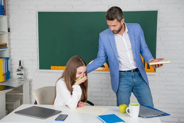 Ridere bambino studio in classe con insegnante confuso — Foto Stock