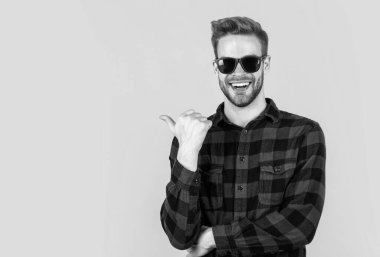 Moda tarzı olan şık bir adam. Kareli gömlek, gözlük ve aksesuar giyiyor.