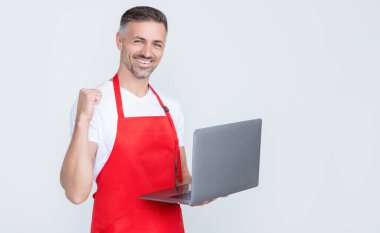 successful mature man in apron chatting on computer