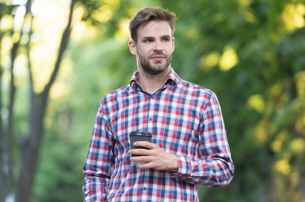 young man smile in checkered shirt with coffee cup