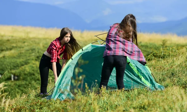 Women set up tent on top mountain. Hiking activity. Attach necessary structural components tent. Prepare for night. Girl scout concept. Camping hiking. Helpful to have partner for raising tent — Zdjęcie stockowe