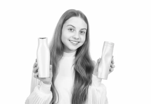 Щаслива дівчина-підліток, що представляє шампунь або пляшку кондиціонера для волосся ізольована на білому, кератин — стокове фото
