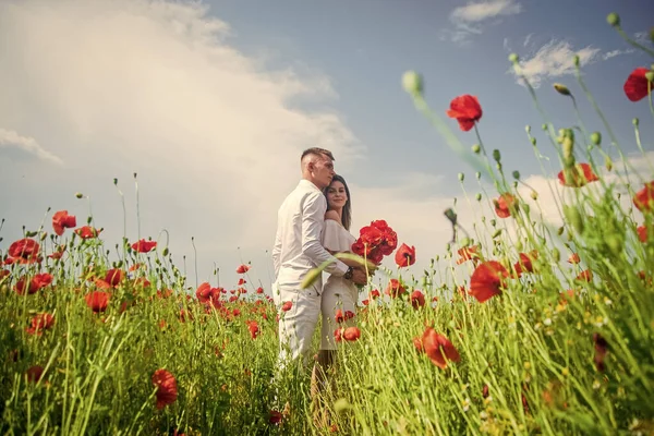 Pareja feliz enamorada caminando en hermoso campo de flores de amapola en el día romántico, boda — Foto de Stock