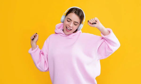 Θετική νεαρή κοπέλα ακούσετε μουσική σε ακουστικά σε κίτρινο φόντο — Φωτογραφία Αρχείου