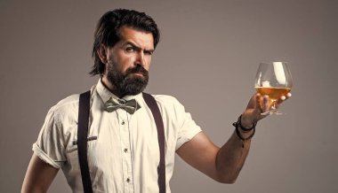 Resmi giyinmiş zarif, vahşi bir adam saçını yaptırmış viski ve alkol içiyor.