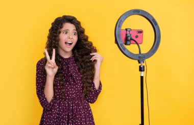 Uzun kıvırcık saçlı kafası karışık bir çocuk blog için video yapıyor