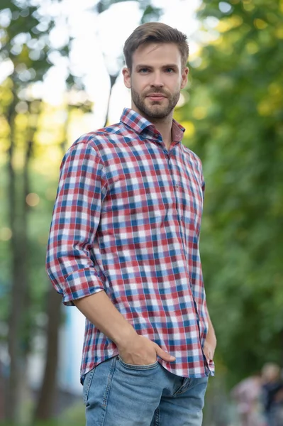 Confident young man in checkered shirt outdoor — Stock fotografie