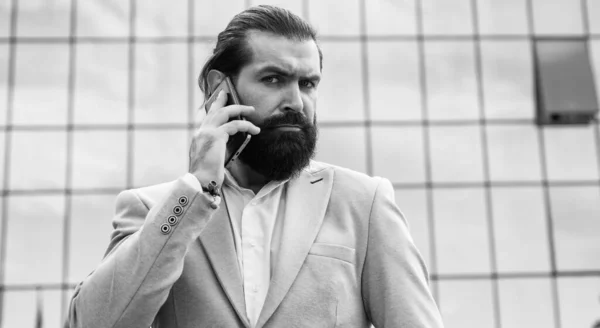 Przystojny Dojrzałe brodaty mężczyzna w formalny garnitur mówić na telefon zewnątrz, zwinny biznes — Zdjęcie stockowe