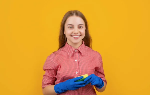 Happy child in rubber gloves with sponge on yellow background — Fotografia de Stock