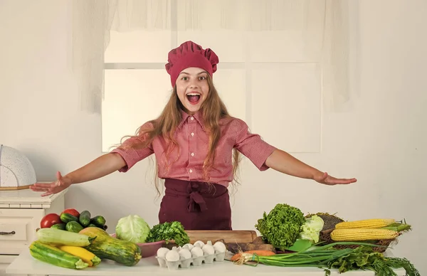 Счастливая девочка в кулинарной шляпе и фартуке на кухне, здоровье — стоковое фото