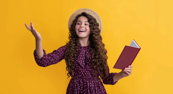 Positive child with frizz hair recite book on yellow background — Stockfoto