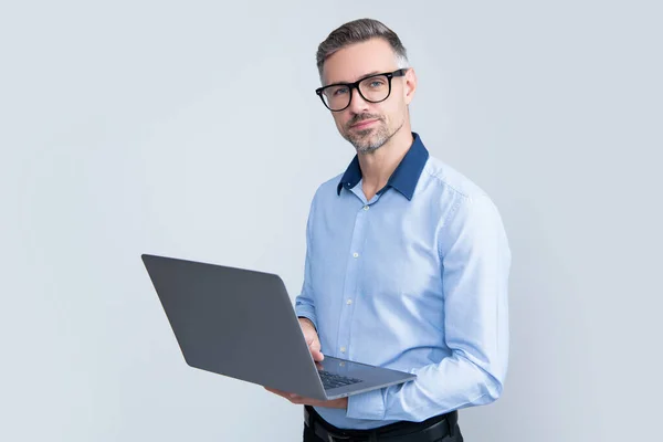 Mature employee in eyeglasses working on computer on grey background — Foto de Stock
