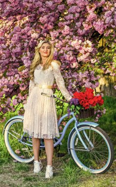 Baharın tadını çıkarıyorum. Doğal kadın güzelliği. Bahçedeki kadın. Kiraz çiçeklerinin yanında retro motorsikletli genç, modaya uygun bir kız. Pembe Sakura sokağında klasik bisikletli bir kız. Bahar zamanı çiçek açan ağaç