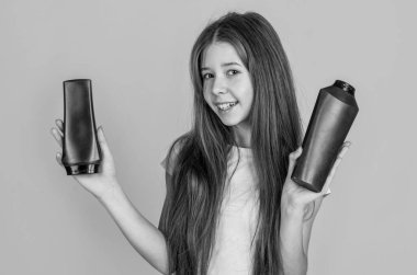 Buraya bak. Çocuk şişede şampuan kullanıyor. Saç kremi. Güzellik. Yıka ve durula. Mutlu genç kız kozmetik ürünleri sunuyor. Kuaförde saç şampuanlıyordum. Günlük alışkanlıklar ve kişisel bakım