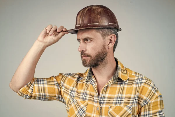Man architect met serieuze blik. Hij draagt een arbeidersuniform. knappe bouwer in helm. — Stockfoto
