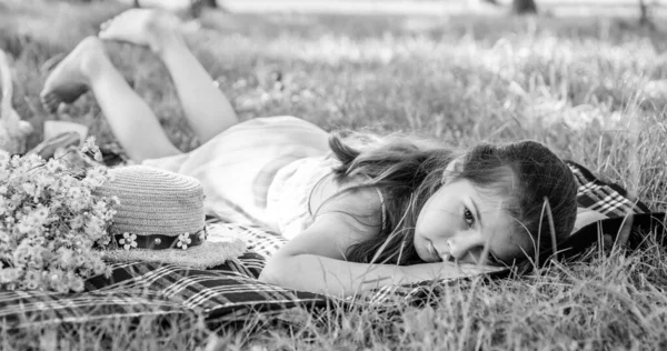 Pequena menina relaxe no cobertor de piquenique na grama verde na paisagem ensolarada de verão, descanso — Fotografia de Stock