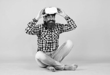 Adam kablosuz internet gözlüğü takıyor. VR kulaklıklı adam. Sakallı hippi modern teknoloji kullanır. Dijital gelecek ve yenilik. Sanal gerçeklik gözlüğü takan acımasız bir adam. Mutlu gelecek