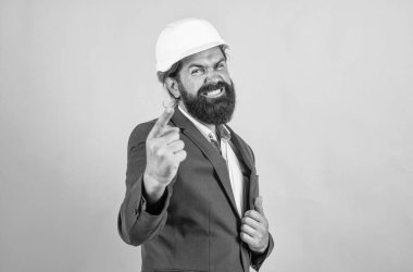 Sakallı işçi. Sırada sen varsın. Mutlu ya da agresif kasklı olgun bir mimar. Vahşi sakallı adam şantiyede çalışıyor. Proje üzerinde çalışıyorum. bina konsepti. İnşaatçı ya da mühendis.