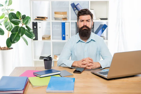 Serious professional man sitting at office desk clasping hands, professionalism — kuvapankkivalokuva