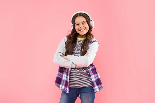 Glad unge lyssna musik i hörlurar på rosa bakgrund, tillbaka till skolan — Stockfoto