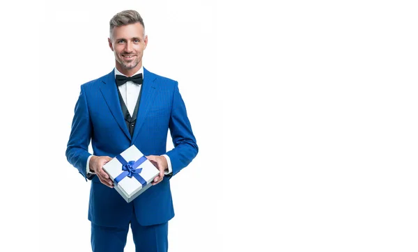 Cheerful man in blue suit with gift box isolated on white. valentines day — Stockfoto