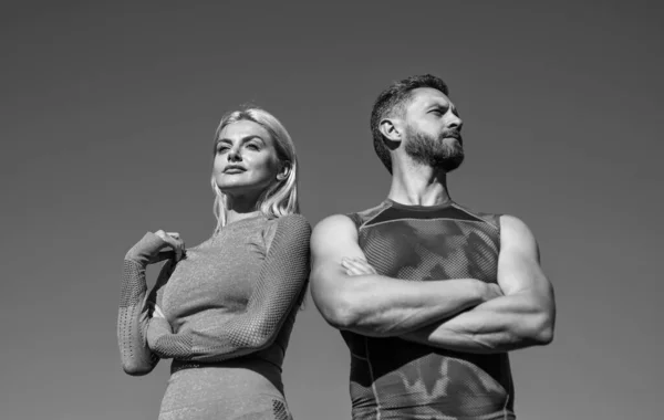 Couple sportif confiant. homme musclé et femme sexy en vêtements de sport. les athlètes ressentent le succès. — Photo