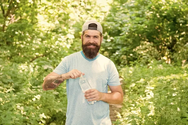 Killen upprätthåller kroppsvattenbalansen. vätskebrist. Dagligt vatten. brutalt skäggigt man dricka flaska. — Stockfoto