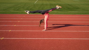 Her zaman öğrenilecek yeni bir numara vardır. Kız amuda kalkar ve bacaklarını ayırır. Amudu böl