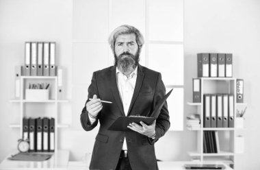 Dosyası olan bir iş adamı. Kontrol ve teftiş. Sakallı adam not alıyor. Denetleyici müfettiş kontrol ediyor. Proje müdürü. İş adamları konsepti. Belgeleri elinde tutan kendinden emin bir işadamı.