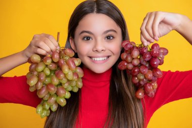 Kız gülüşü Sarı arka planda üzüm demeti