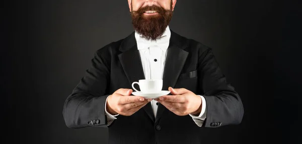 Smokinli, papyonlu, kahve fincanı takan mutlu bir adam. Kahve servisi yapan garsonum. — Stok fotoğraf