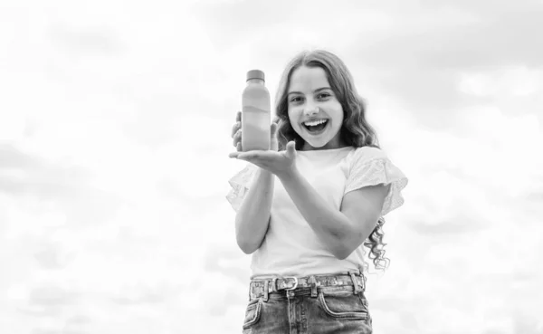 Χαρούμενο παιδί που παρουσιάζει χυμό ή νερό σε μπουκάλι για δροσιστική, βιταμίνη — Φωτογραφία Αρχείου