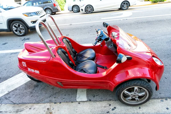 Miami Beach, Florida USA - April 14, 2021: red scootcoupe moped, side view. scooter for touring. — стоковое фото