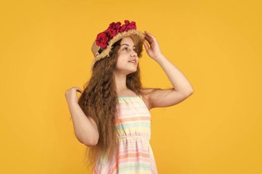 Yaz konsepti. Yazlık giysiler içinde neşeli bir çocuk. Bahar çocuğu modası. Gül çiçekli kız.