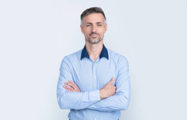 Gri arka planda ofis gömleği içinde gülümseyen olgun iş adamı.