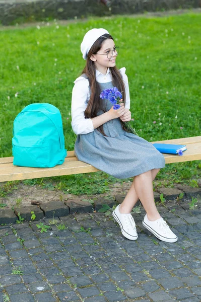 Happy child in glasses relax on park bench with flowers. teachers day — стоковое фото