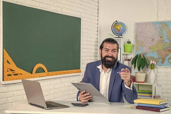 Взрослый бородатый парень в костюме держит блокнот и думает об экзаменах, учительский день — стоковое фото