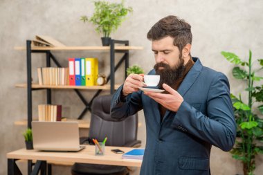 mature entrepreneur in jacket enjoy smell having coffee break at office, morning