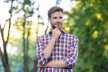 Dışarıdaki kareli gömlekli neşeli genç adam.