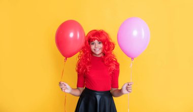 Sarı arka planda parti balonu olan pozitif çocuk