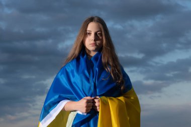 patriotic teen ukrainian child with national flag of ukraine